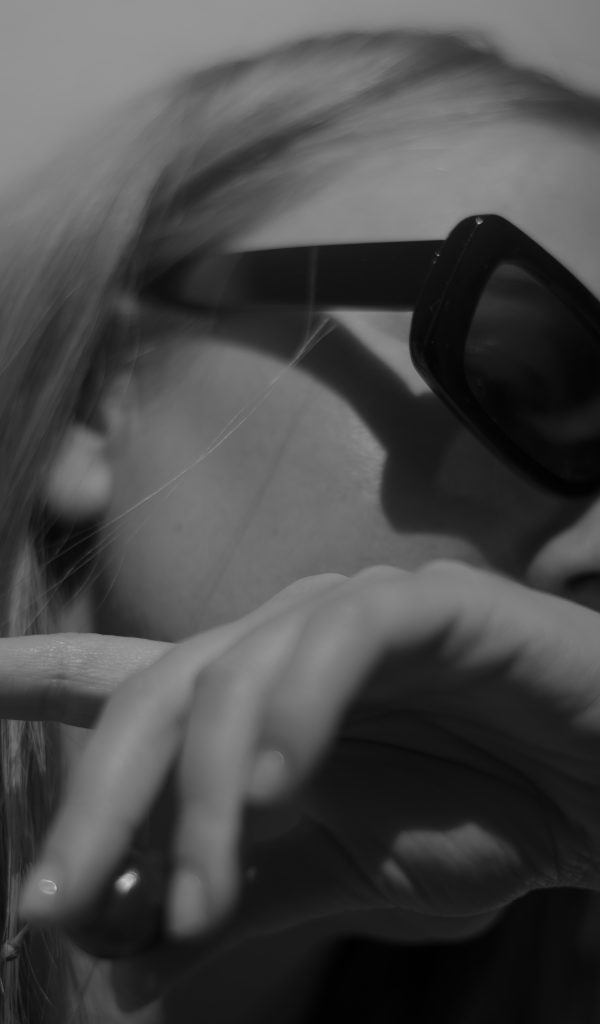 Stylish woman in sunglasses exuding confidence and mystery