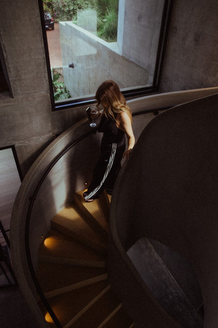 Woman creating main character energy vision board with photos and quotes for 2026 identity transformation and manifestation