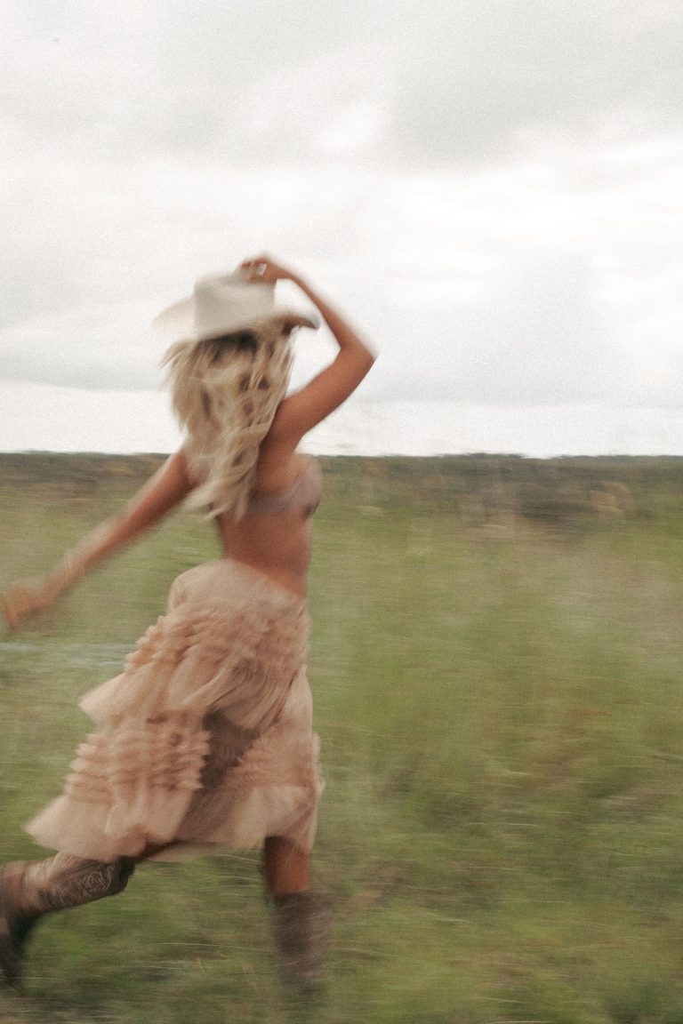Young woman writing in journal with coffee and plants, representing that girl building 2026 habits through identity transformation and morning routine success