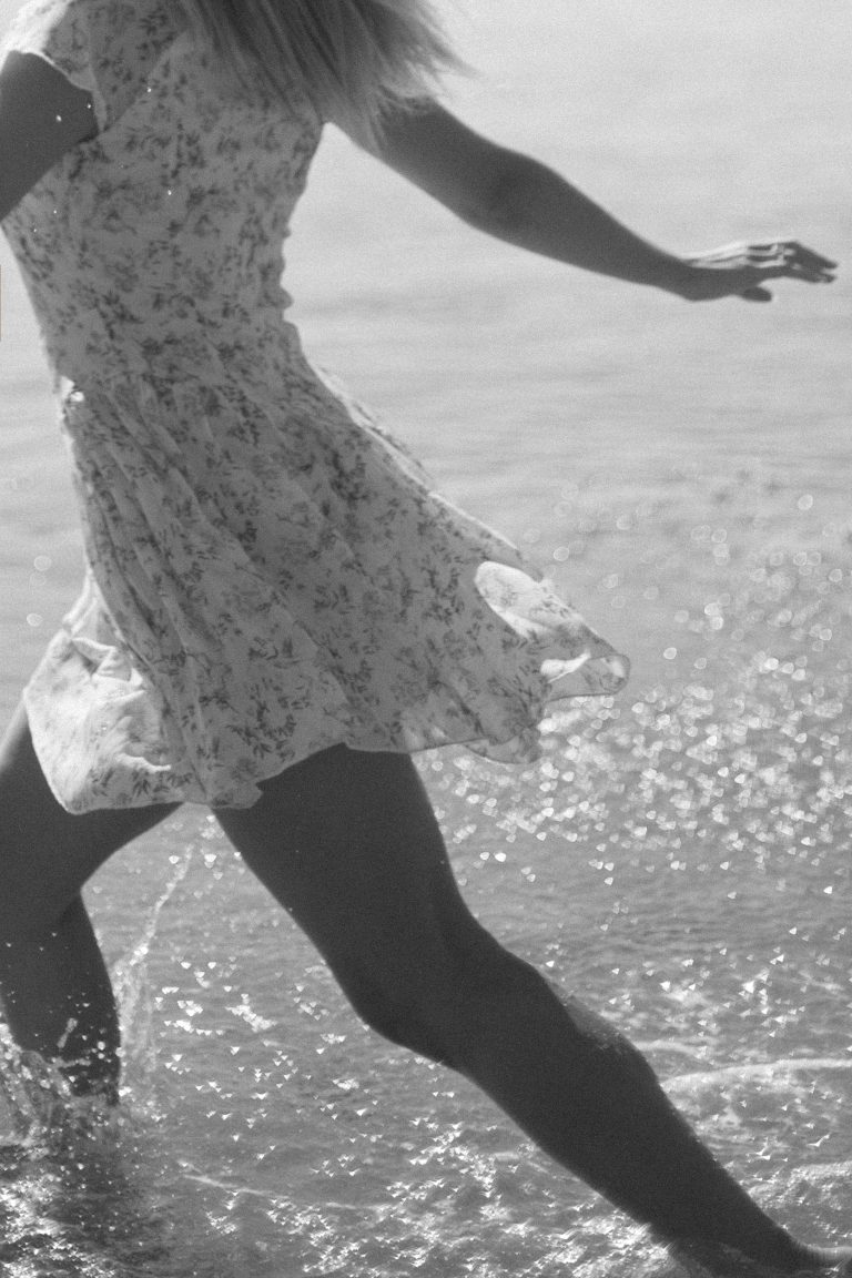 Woman creating vision board for 2026 goals with photos and quotes representing that girl lifestyle and identity transformation